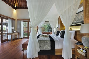 Un dormitorio con cama a dosel, suelo de madera y vistas al exterior.