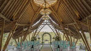 An arched bamboo structure with a central aisle and chairs on either side, leading to an archway. - The Kayon Jungle Resort (Payangan)