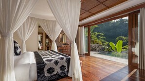A bedroom with a bed, a nightstand, a mirror, and a view of an outdoor swimming pool. - The Kayon Jungle Resort (Payangan)