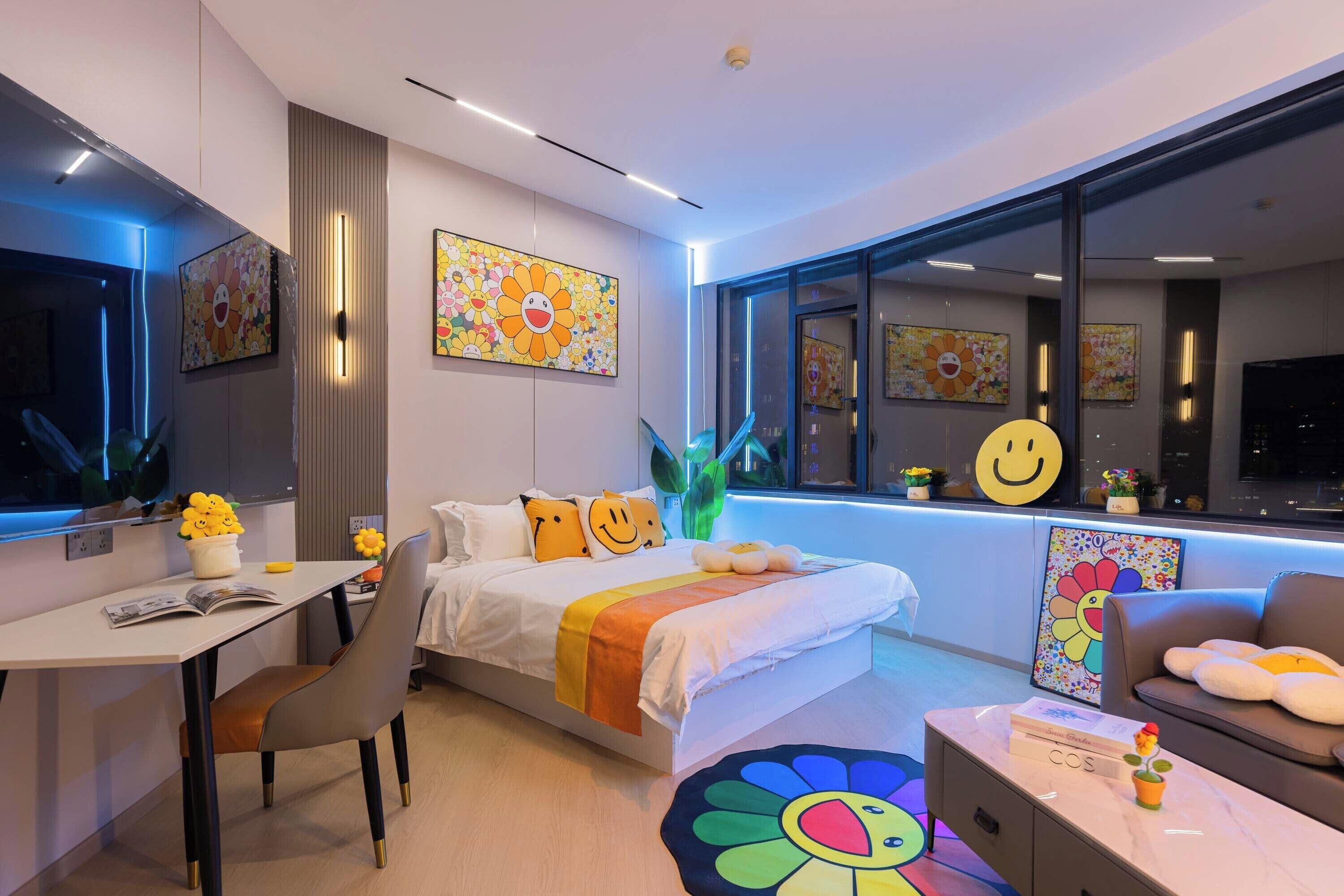 A modern hotel room with a bed, desk, and seating area.