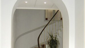 A staircase with a red patterned carpet, a wooden chair, and a potted plant. - Hotel Marcellin (Beaulieu-sur-Mer)