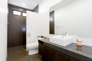A modern bathroom with a large mirror, a white sink, and a toilet. - Big Buddha View 3br Pool Villa by Intira (Rawai)