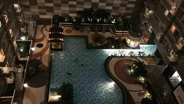 An aerial view of a hotel courtyard with a central pool, surrounded by lounge areas and a checkered floor pattern. - Apartment Sudirman Park 2 Bedrooms & 2 Bathrooms Jakarta (Jakarta)