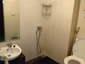A small bathroom with a sink, toilet, and shower.