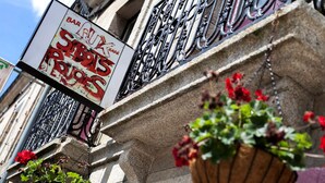 Fachada de un edificio con un letrero que anuncia un bar y restaurante.