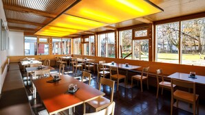 A spacious restaurant with high ceilings, large windows, and a warm, inviting atmosphere. - DJH Garmisch- Partenkirchen - Hostel (Garmisch-Partenkirchen)