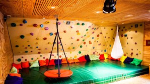 A climbing gym with padded walls, a padded floor, and colorful climbing holds. - DJH Garmisch- Partenkirchen - Hostel (Garmisch-Partenkirchen)
