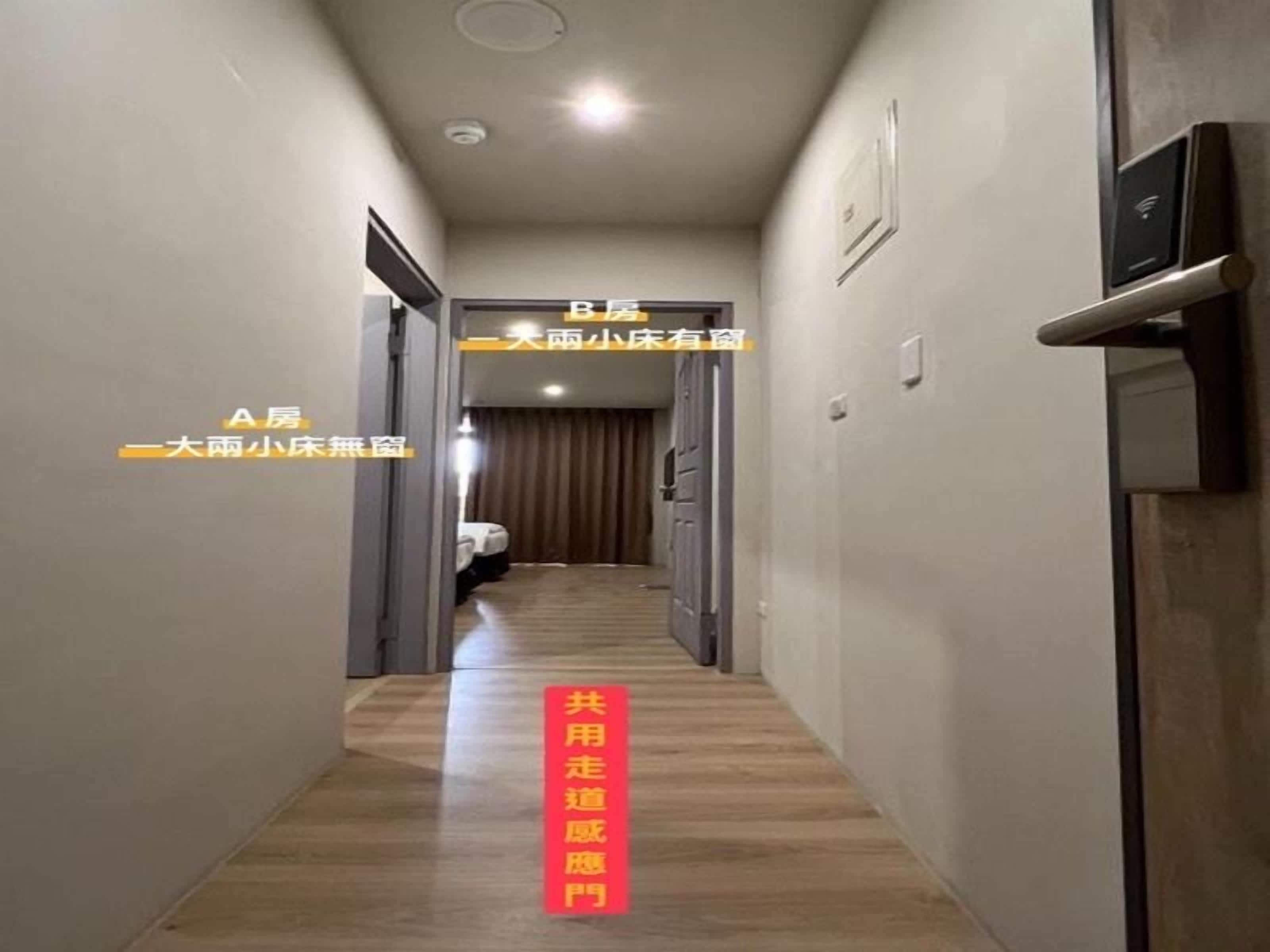 A hotel hallway with doors labeled A and B, a wooden floor, and a red sign with white text.