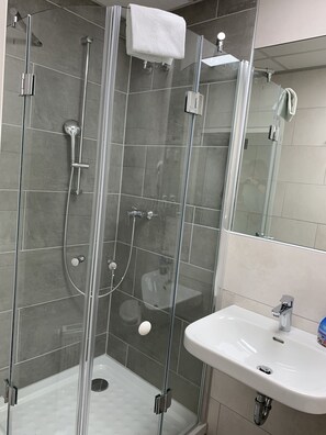 Eenpersoonskamer | Badkamer | Een douche, handdoeken