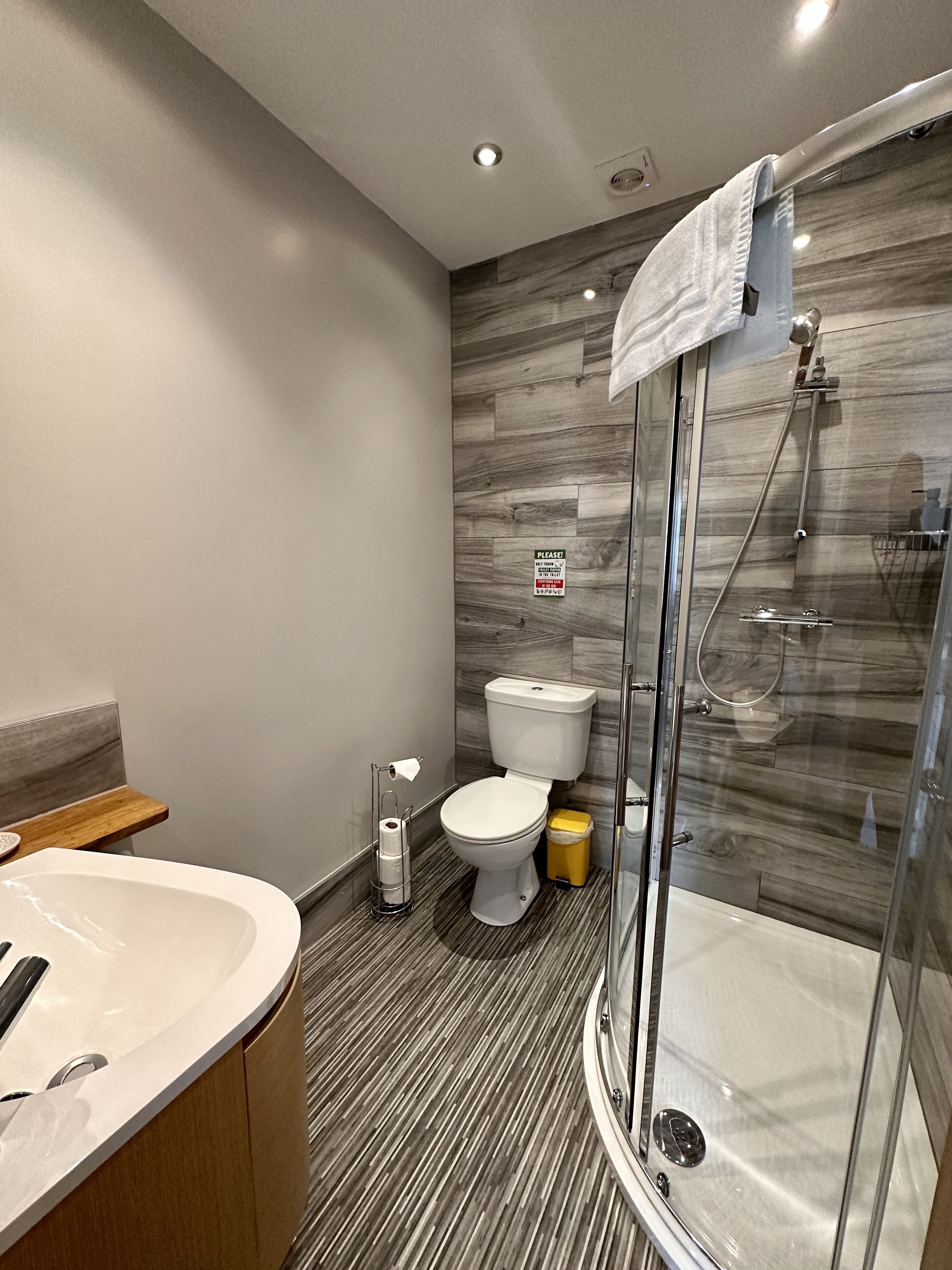Une salle de bain moderne avec une douche à parois de verre, des toilettes et un lavabo.