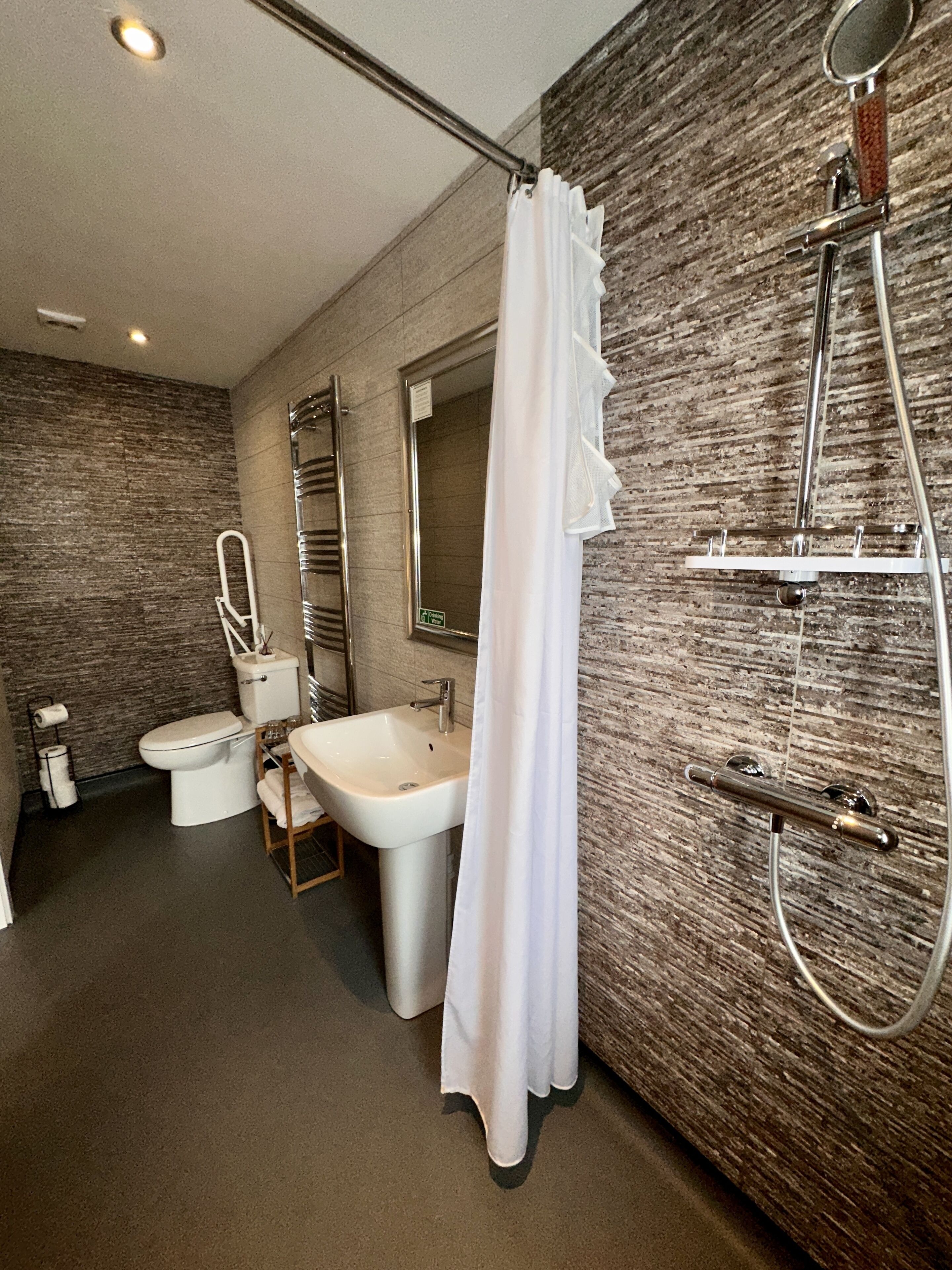 Un baño moderno con ducha, inodoro y lavamanos.