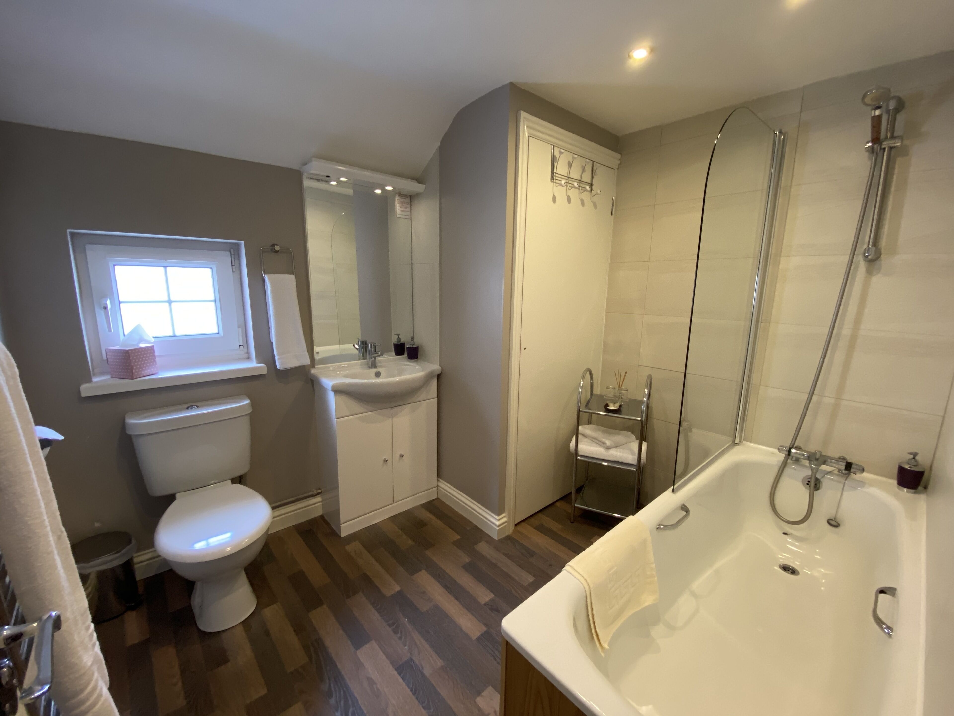 A modern bathroom with a toilet, sink, and bathtub.