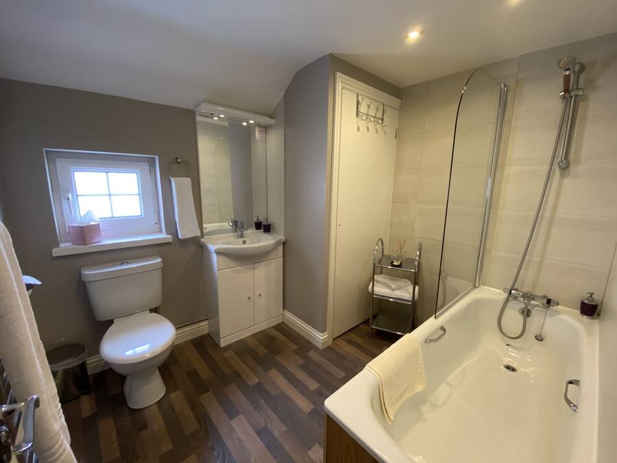 A modern bathroom with a toilet, sink, and bathtub.