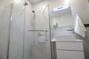 Estudio urbano, 1 cama matrimonial, vista a la ciudad | Regadera en el baño