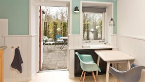 Une cuisine avec une fenêtre, une table et des chaises.