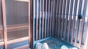 A traditional Japanese gate with vertical slats and a decorative pattern on the lower part. - Zerogravity koniya clubhouse (Setouchi)