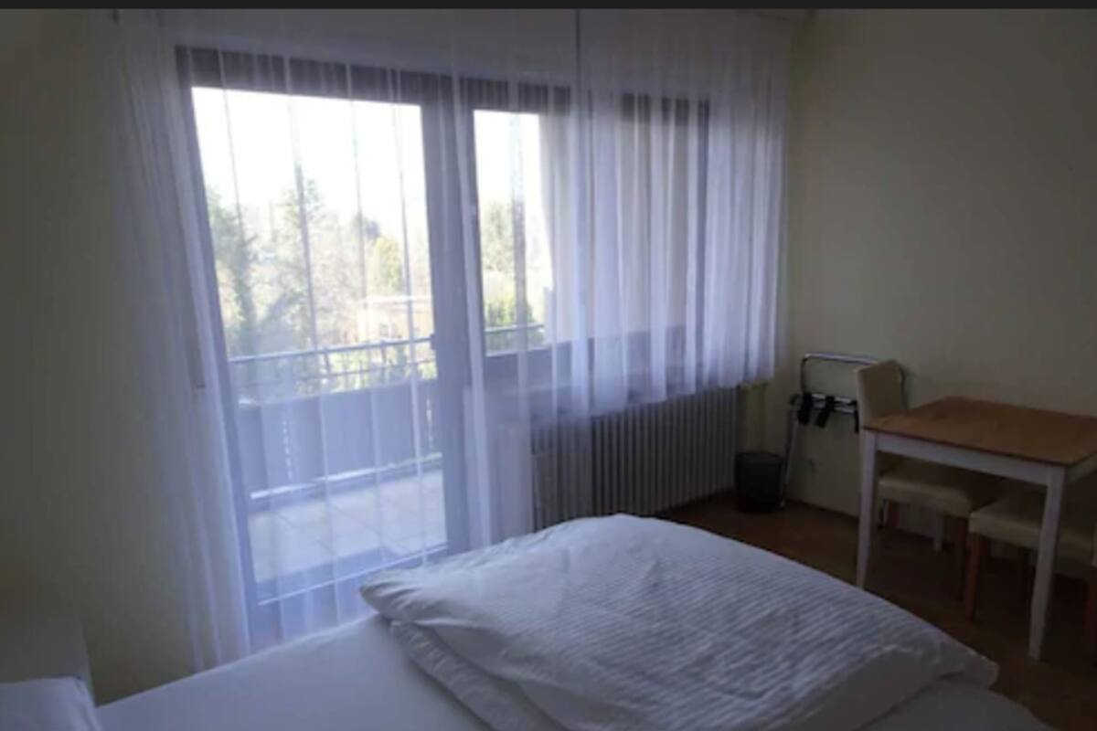 Een hotelkamer met een bed, een tafel en een stoel.