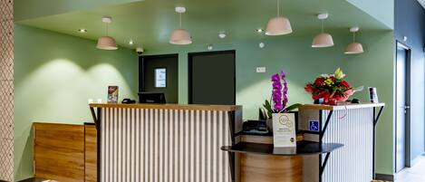 A reception desk with a striped design, a wooden counter, and a flower arrangement.