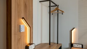 A modern room with a wooden accent wall, a hanging light fixture, and a wooden bench with a built-in charging station.