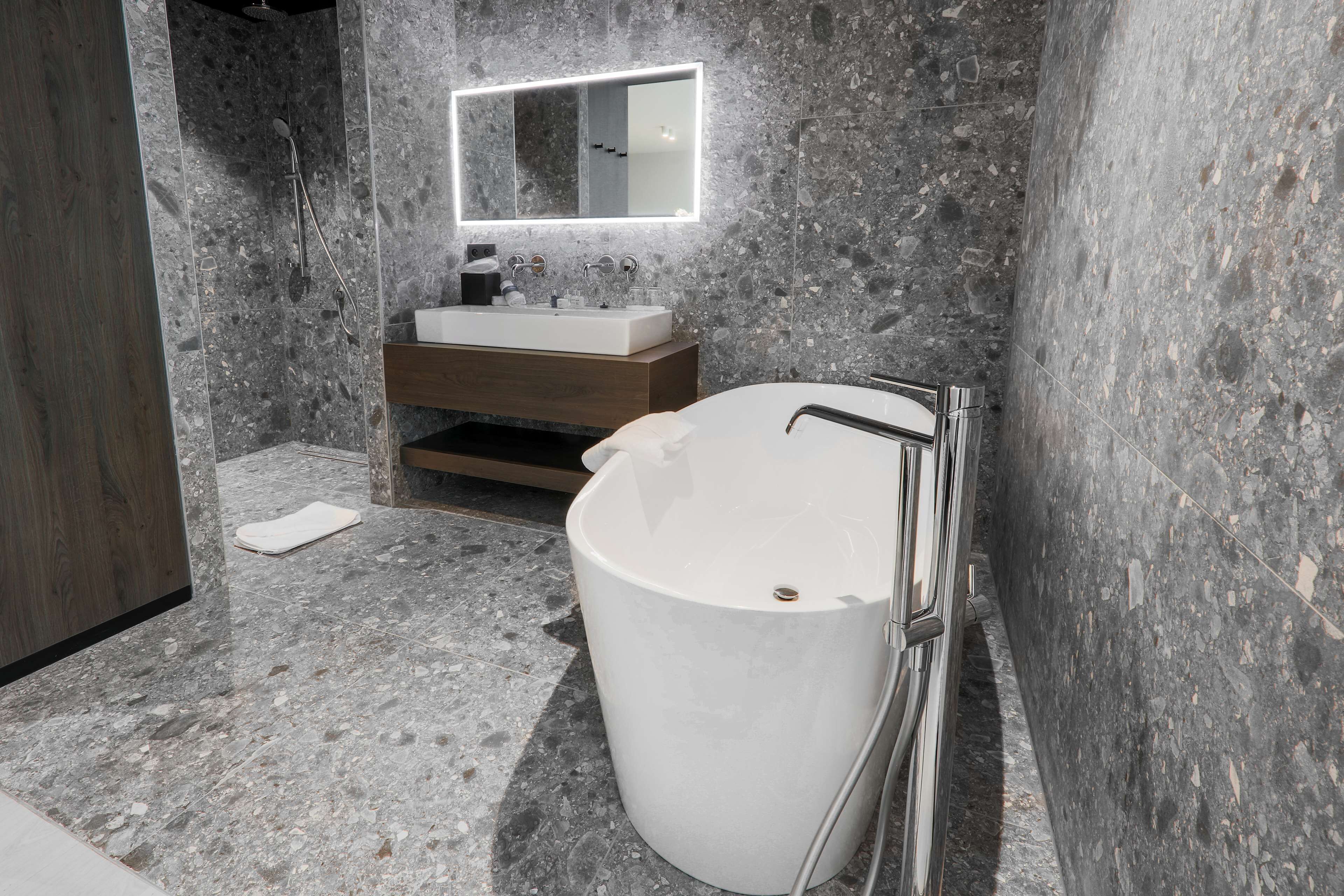 Un baño moderno con una bañera independiente, un tocador con espejo y una zona de ducha.