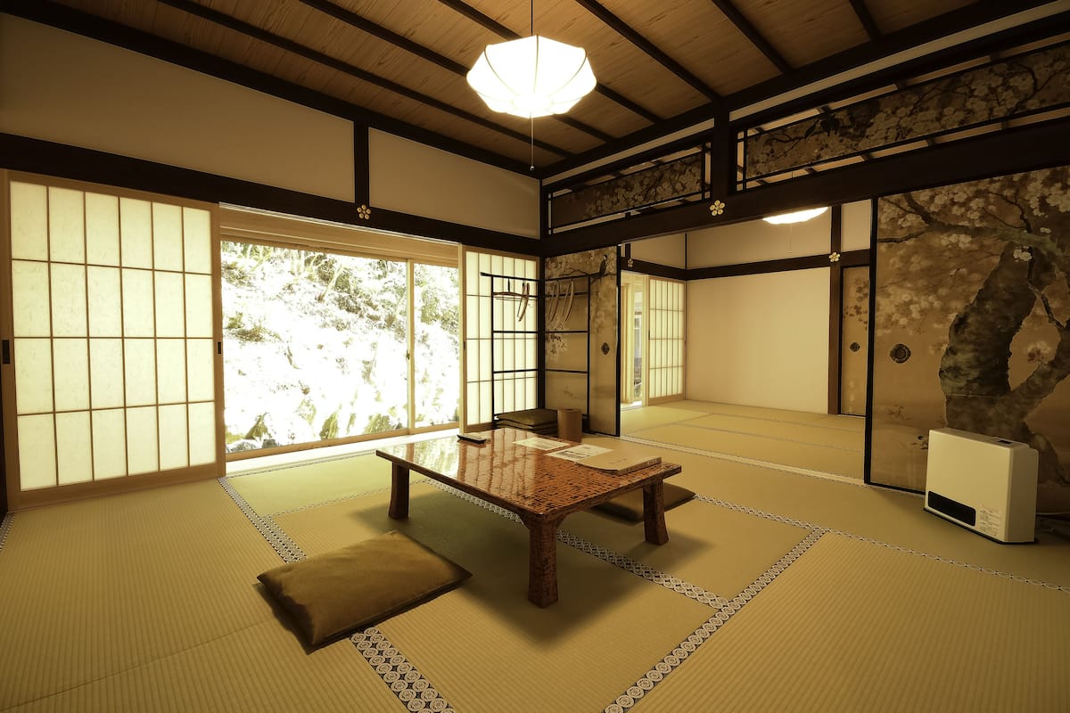 A traditional Japanese room with tatami flooring, a low wooden table, and sliding doors.