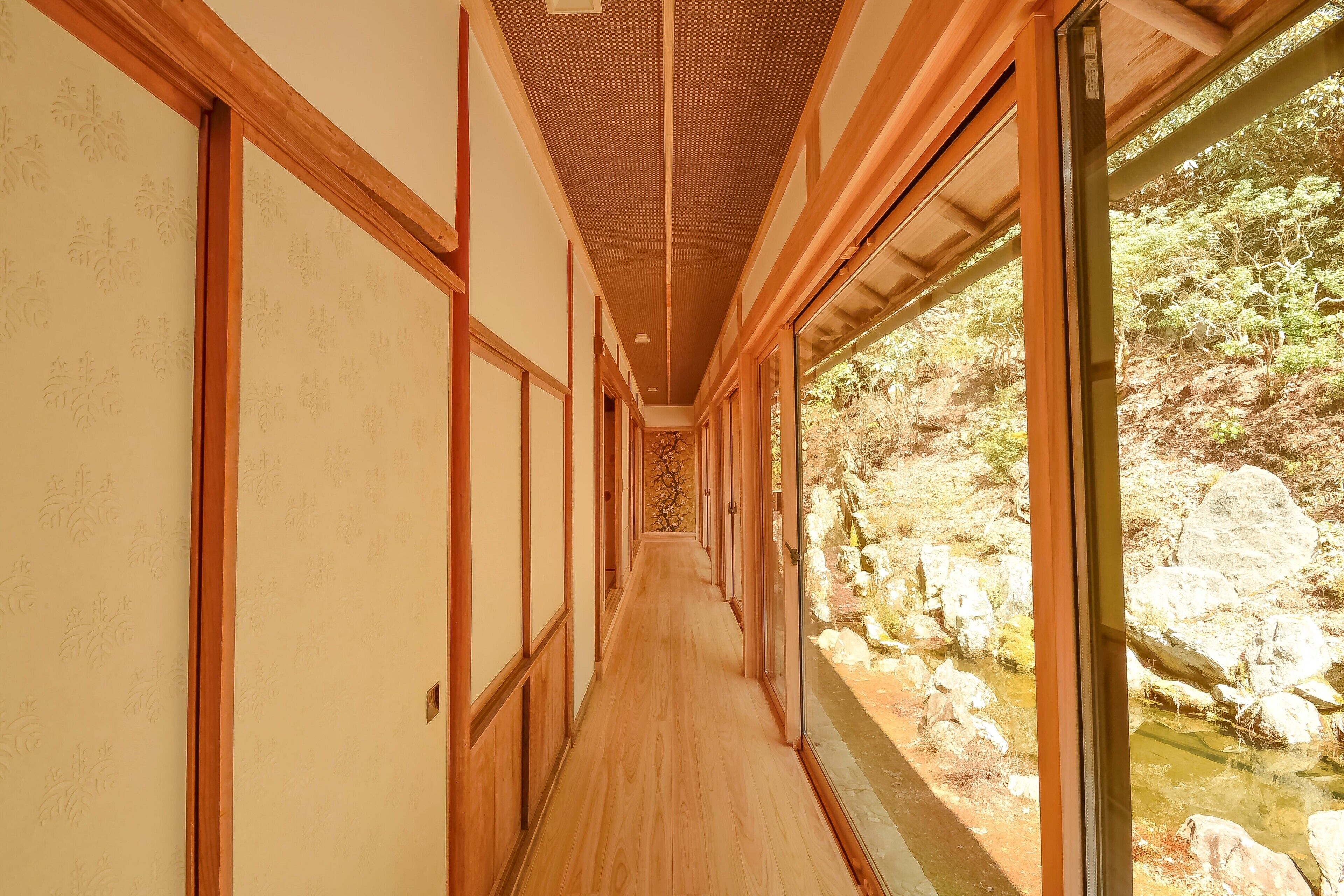 Un couloir doté d’un plancher en bois et de portes coulissantes de style japonais traditionnel.
