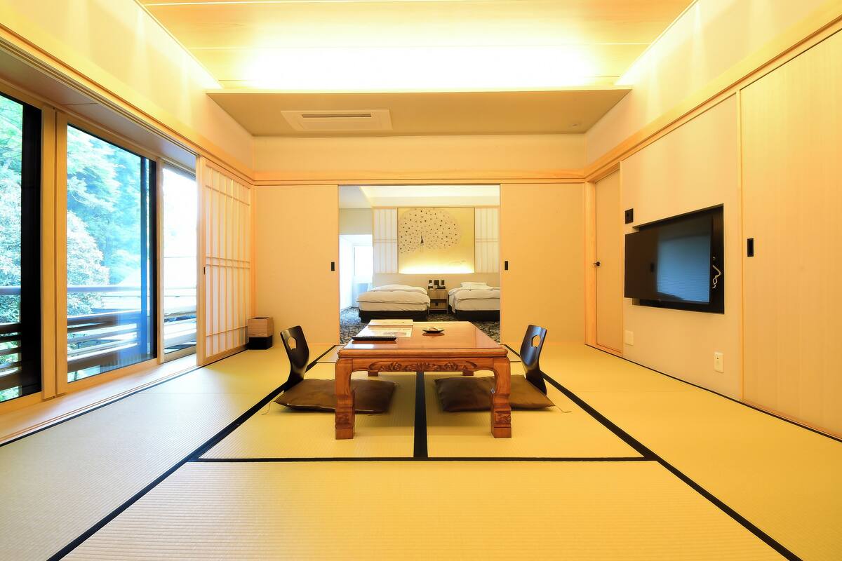 A traditional Japanese-style room with tatami flooring, a low table, and sliding doors.
