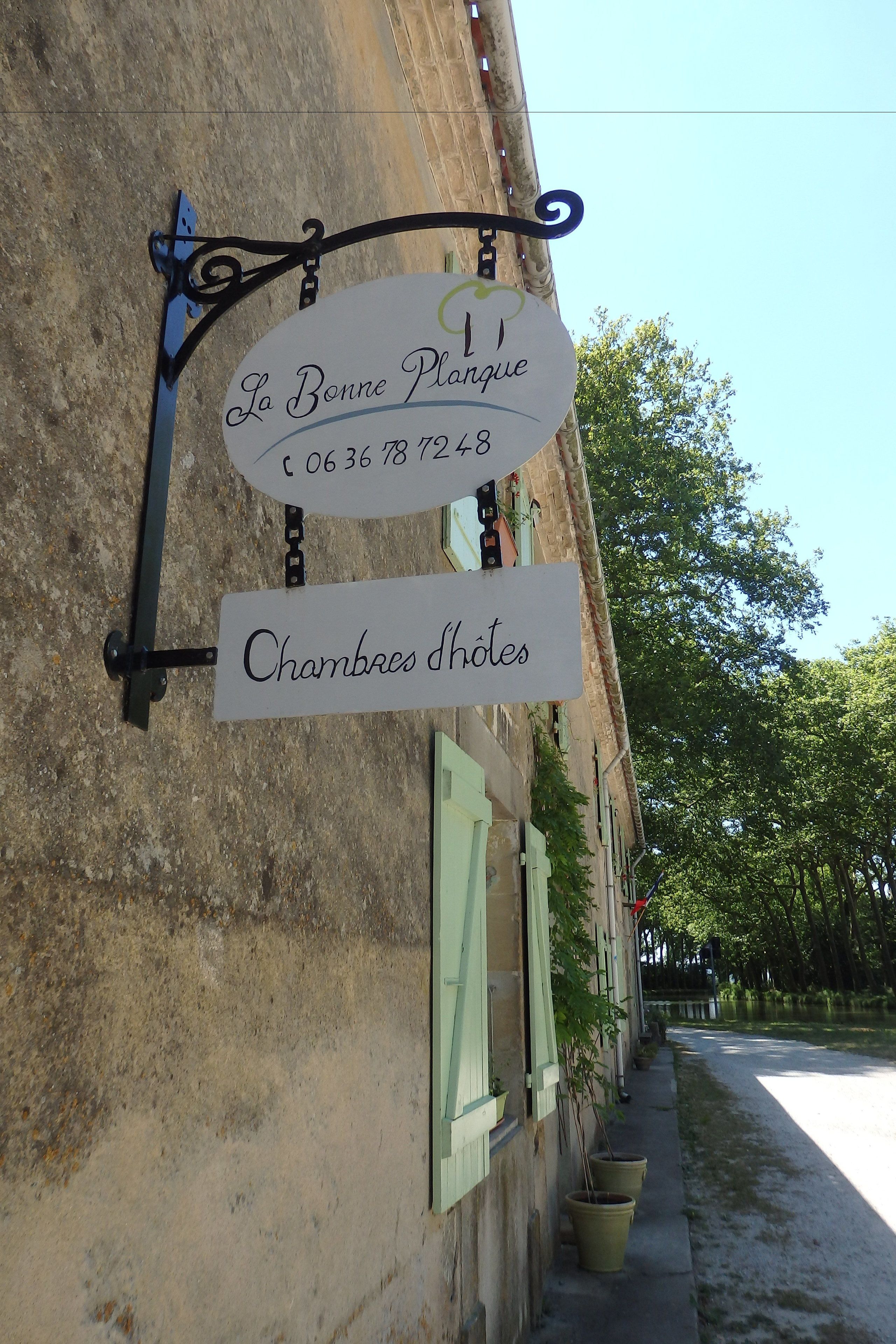 Une enseigne indiquant « La Bonne Plage », avec un numéro de téléphone et l’inscription « Chambres d’hôtes » en dessous.