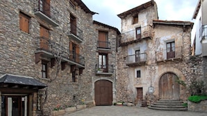 A stone building with multiple balconies and a central courtyard. - Diamo (Castejon de Sos)