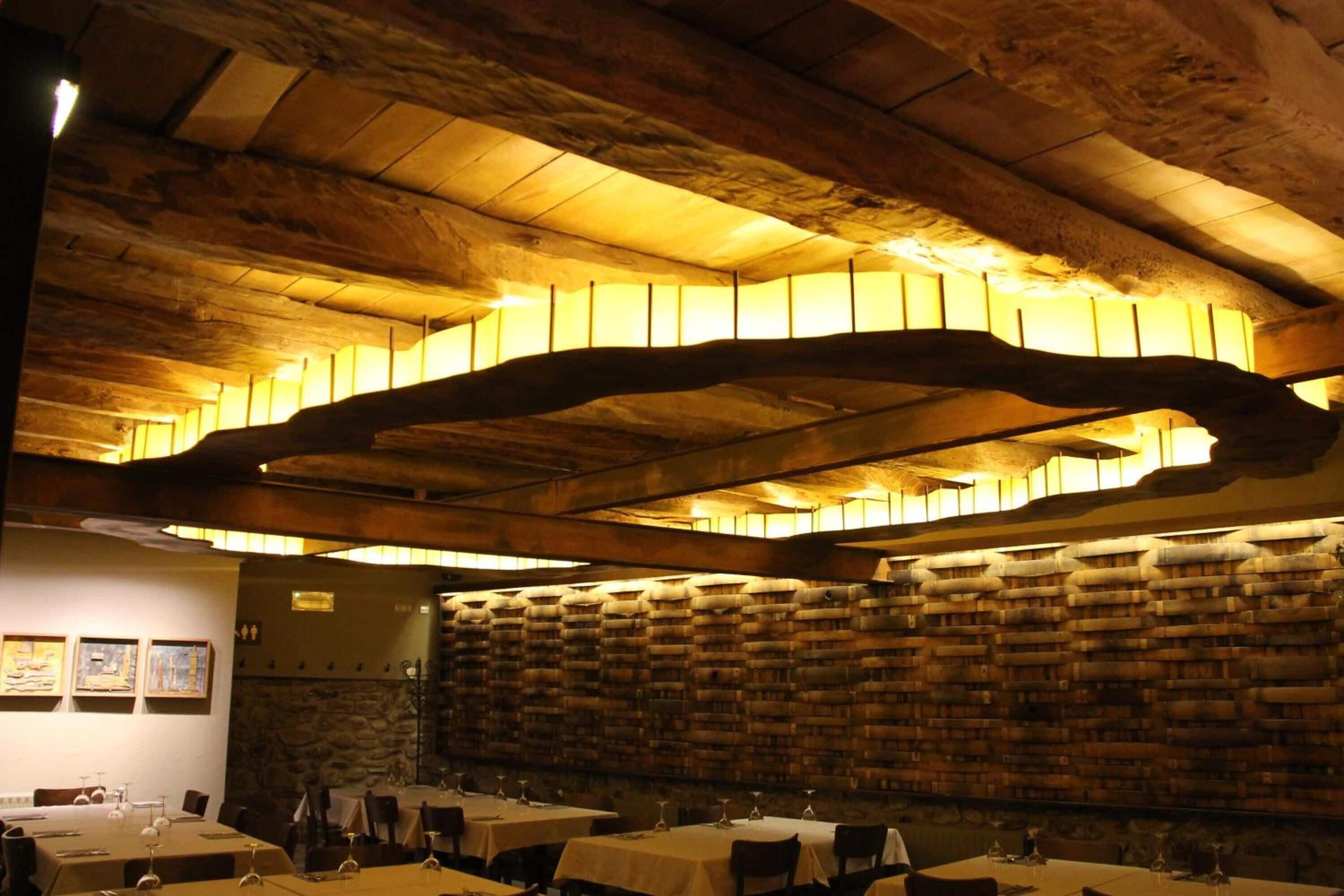 Ein Restaurant mit Holzbalkendecke und gedeckten Tischen.