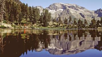 A calm lake reflecting mountains and trees.