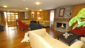 A living room with a fireplace, wooden walls, and a stone accent wall. - Diamo (Castejon de Sos)