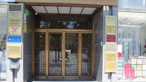 A building entrance with a metal gate and multiple signs indicating various services. - Centro Storico B&B (Foggia)