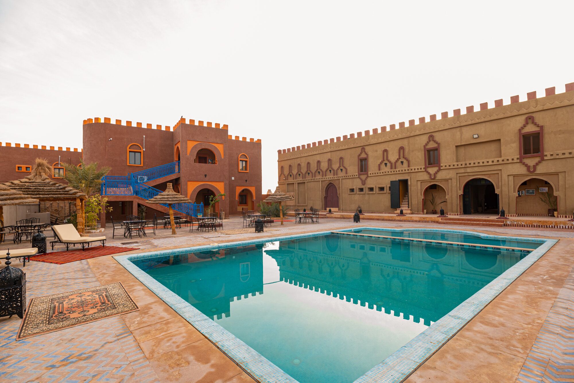 Un patio con piscina, mobiliario exterior y arquitectura tradicional.