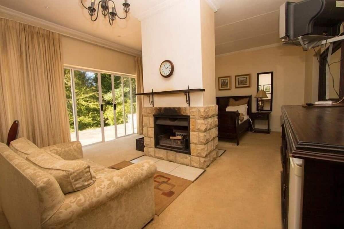 A living room with a stone fireplace, a sofa, and a television.
