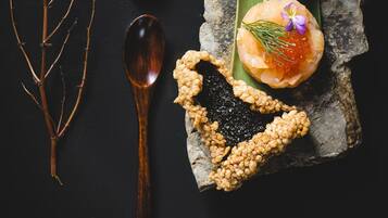 Un postre sobre una roca, con una cuchara y algunas ramas.