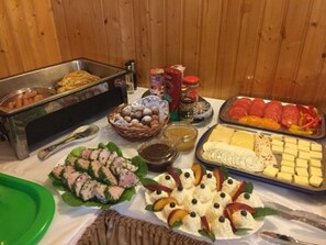 A buffet table with various food items including sushi, cheese, and fruits. - Agroturystyka Katarzyna Tarasiewicz (Suwalki)