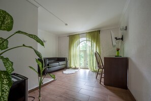 Una sala moderna con un sofá, una mesita y una planta.