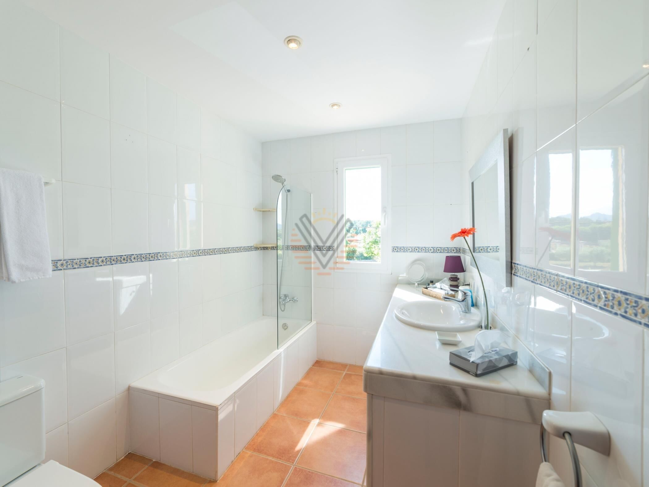 A modern bathroom with a glass-enclosed shower, a bathtub, and a vanity with a mirror.