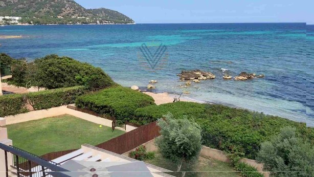 A coastal property with a view of the sea, a grassy lawn, and a mountain in the background. - Sa Copinya, Villa in front line of the beach, Mallorca (Son Servera)