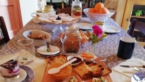Une table à manger avec différents plats, notamment des œufs, du pain et une carafe.
