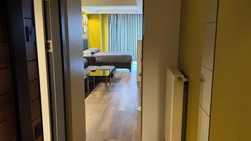 Een gang die leidt naar een slaapkamer met een bed, een bank en een tafel.