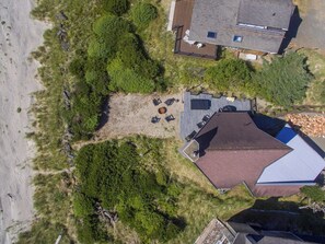 An aerial view of a property with a large deck, a swimming pool, and a house with a sloped roof. - Lighthouse - Oceanfront, stunning, updated classic (Cloverdale)