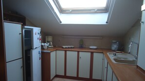 A compact kitchen with a skylight, a refrigerator, a coffee maker, and a sink. - Sea View Athina's Home (Kefalonia)