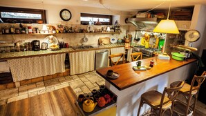 Una cucina con pavimento in legno, un'isola centrale e sgabelli da bar.