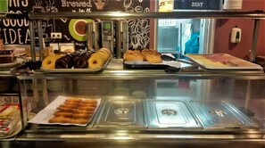 A bakery display case with various baked goods including donuts, croissants, and pastries. - Residencia Universitaria Resa Hernán Cortés - Centro Adscrito a REAJ (Salamanca)
