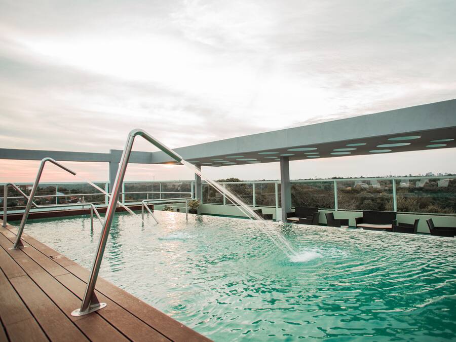 Una piscina al aire libre, sillones reclinables de piscina