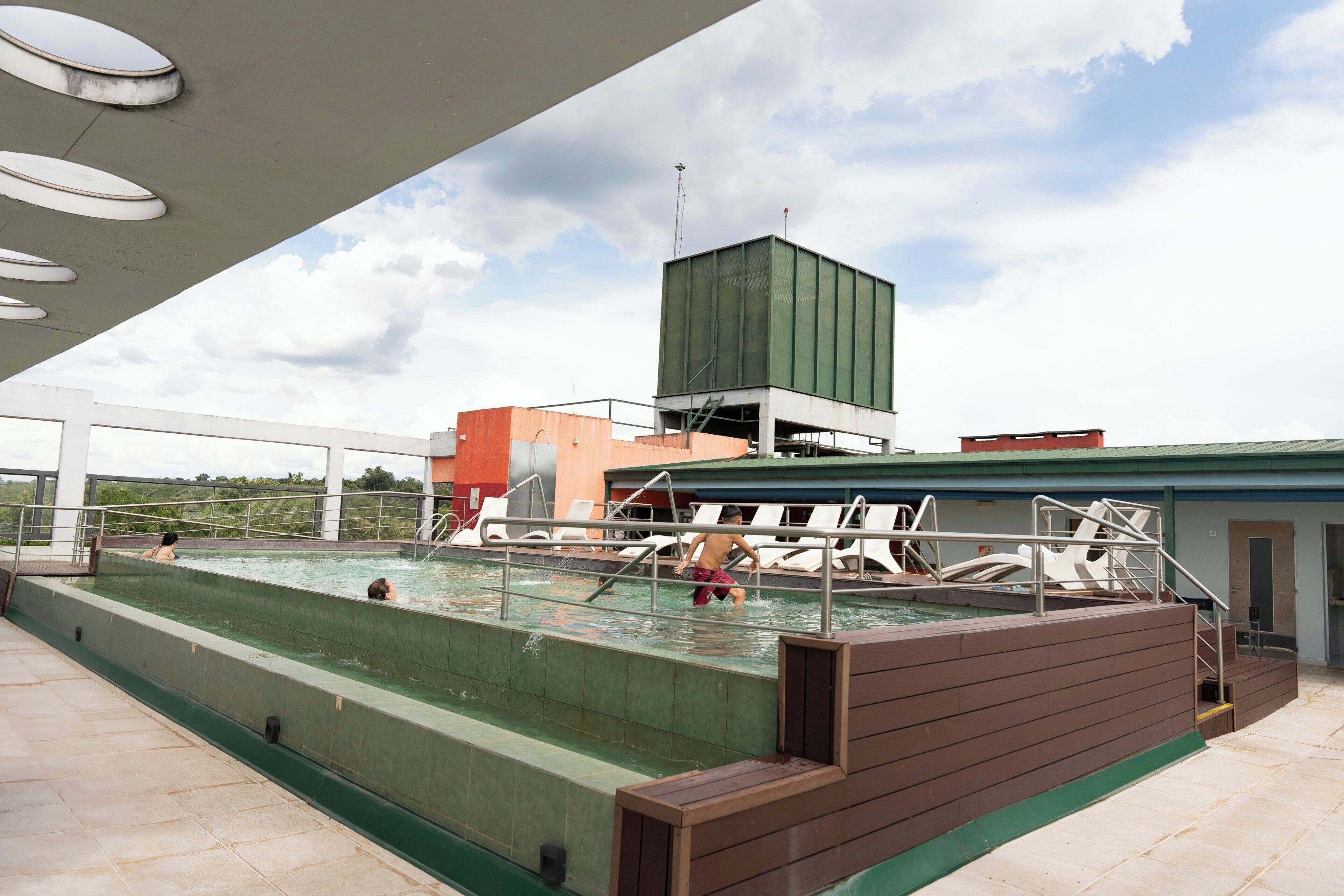 Una piscina al aire libre, sillones reclinables de piscina