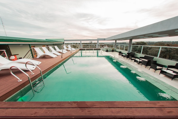 Una piscina al aire libre, sillones reclinables de piscina