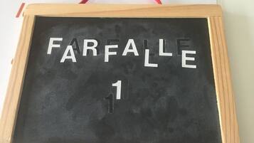 Una pizarra con la palabra "FARFALLE" y el número "1" escrito.